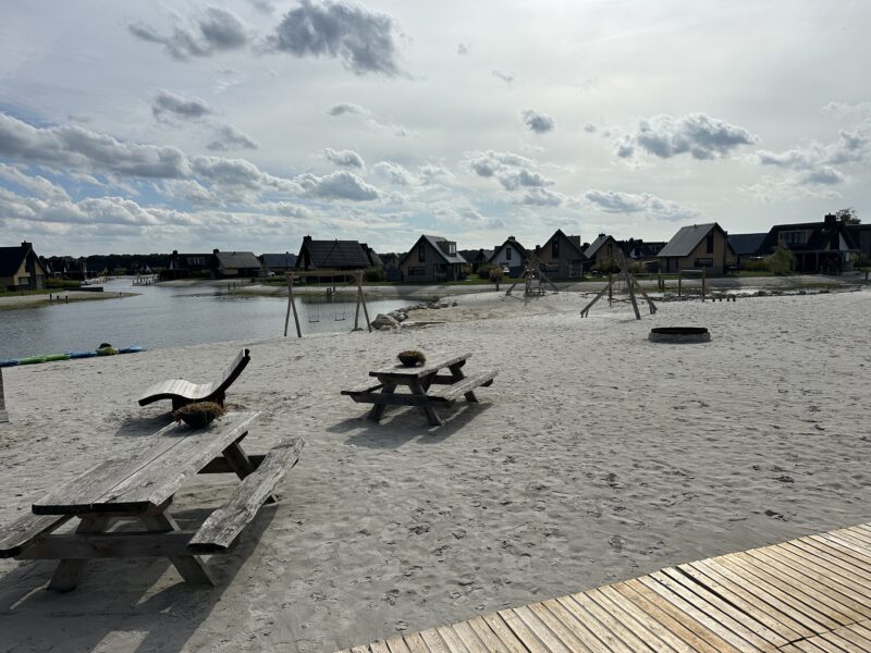 Zandstrand en lagune met speeltoestellen op Landal Drentse Lagune
