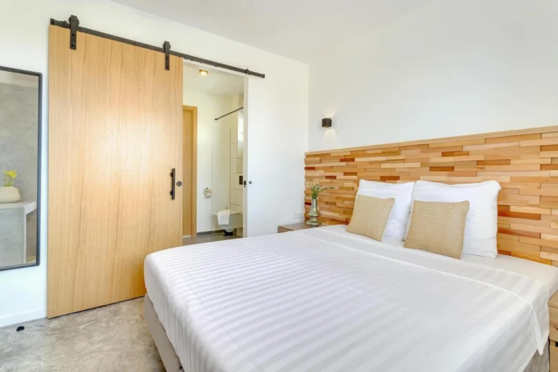 Slaapkamer met houten hoofdbord bij Belnem House Bonaire