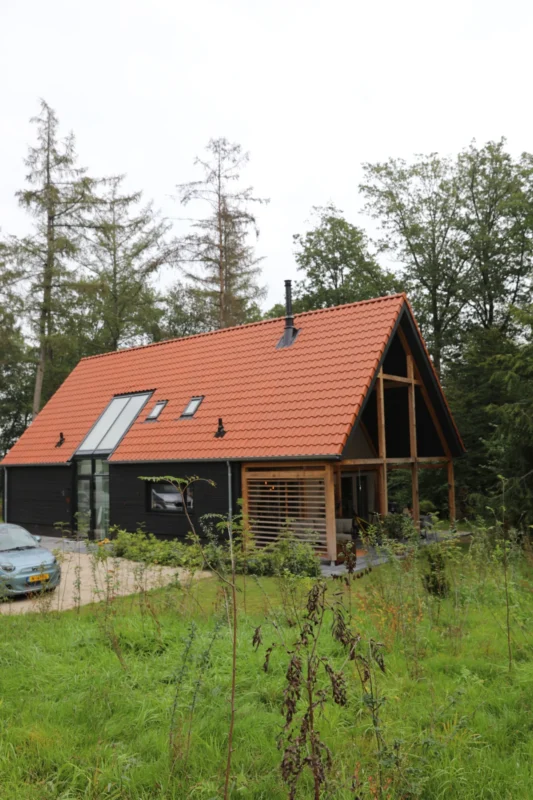 Vakantiehuis met rood dak tussen de bomen op Buytenplaets Rhenen