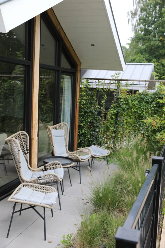 Stoelen op het terras naast een lodge op De Thijmse Berg