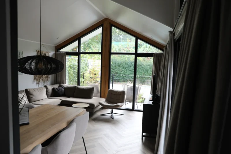 Woonkamer met hoge ramen op De Thijmse Berg