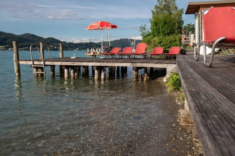 Zonneterras bij de toegang tot het meer bij EuroParcs Wörthersee