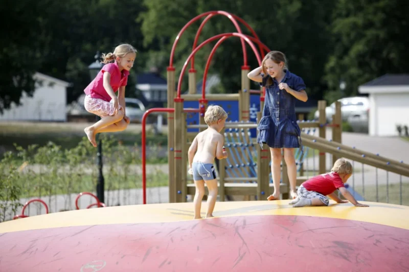 Kinderen op het springkussen en bij speeltoestellen van Familiehuis Nunspeet