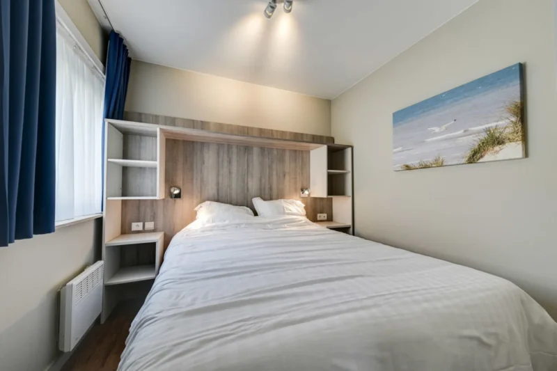 Slaapruimte met tweepersoonsbed bij Holiday Suites De Haan