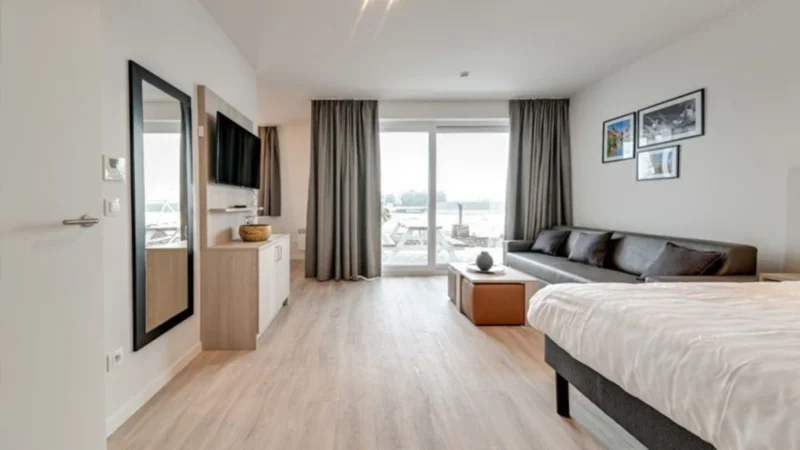 Woonruimte met balkon bij Holiday Suites Jabbeke Klein Strand