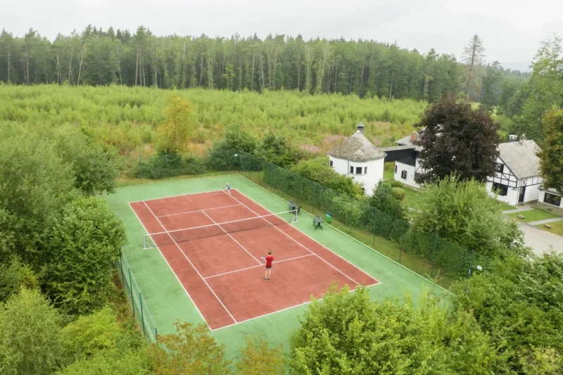 Tennisbaan tussen het groen bij Landal Village les Gottales