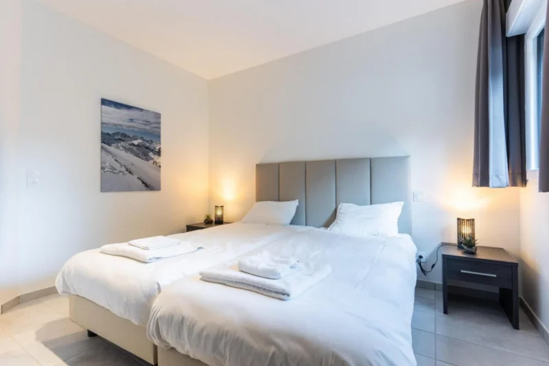 Slaapkamer met tweepersoonsbed bij Résidence Méri-Bellecombe